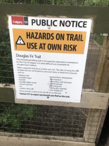 Sign warning of Hazards on Trail. Use at own risk. Douglas Fir Trail. The risks of this trail include, but are not limited to, personal injury or death. Many hazards listed.